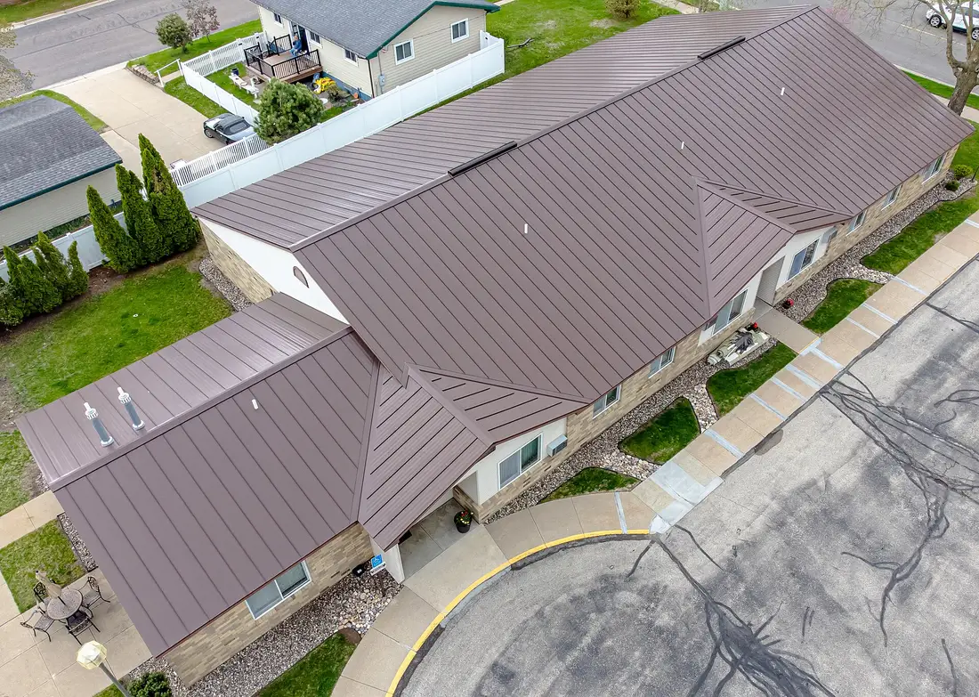 Aerial view of a brown standing seam metal roof on a long single-story building